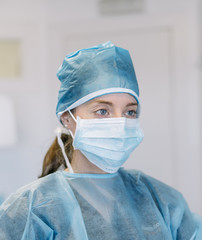 blue-eyed female doctor with mask and epi suit for contagious diseases