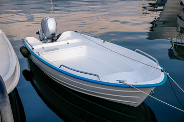 Blue white power boat stops at the port  Small motor boat on a calm , silent sea Reflections ...