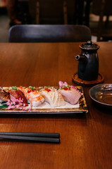 Many kinds of Japanese Sushi on ceramic plate on wood table in restaurant