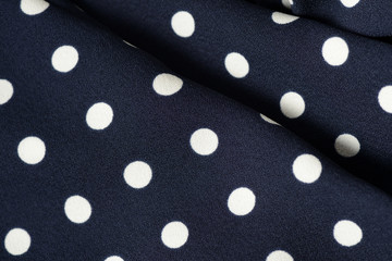 Blue and white polka dot textile background close up