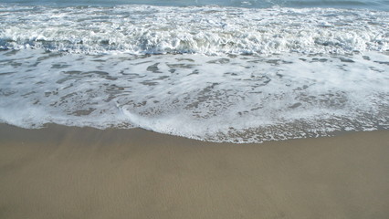 onde e schiume su sfondo di sabbia bagnata nel Mare Adriatico