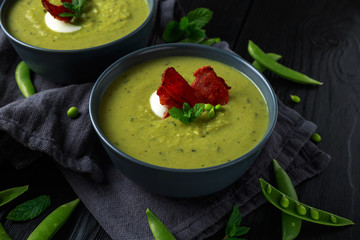 Sweet pea, leek and mint hot soup topped with crunchy bacon and dolop of yogurt