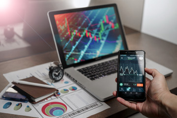 A Computer Tablet and ultra-slim smartphone with candle stick chart on the screen a business and finance conceptual