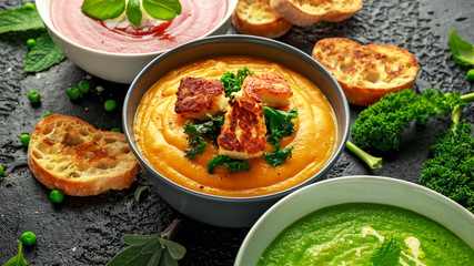 Variety of cream soup bowls: sweet pea and mint, tomato and basil and butternut squash with steamed kale and fried halluomi
