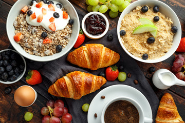 Healthy Breakfast served with coffee, orange juice, croissants, egg, cereals, oatmeal and fruits.