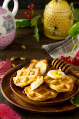 Thanksgiving baking. Belgian Walnut Wafers on a wooden kitchen table, served with fresh banana slices and honey.