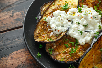 Healthy vegeterain Oven baked aubergines, Eggplant with cottage cheese dip, parsley and lemon wedge.