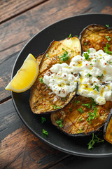 Healthy vegeterain Oven baked aubergines, Eggplant with cottage cheese dip, parsley and lemon wedge.