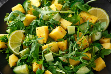 Pineapple Cucumber salad with wild green rocket, lime and olive oil. Healthy juicy food