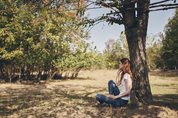young woman sitting by a tree nature