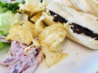 Cheese and relish baguette sandwich served with coleslaw and crisps 