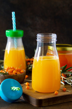 Sweet drink juice with fresh sea buckthorn on a rustic background. Copy space.