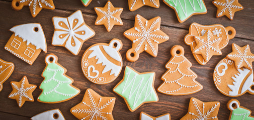 Christmas homemade gingerbread house cookie over wooden background. Sweets as a gift for the new...