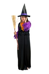 A full-length shot of a Little girl dressed as a witch for halloween holidays covering both ears with hands isolated on white