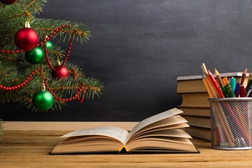 Teacher's table with books, organizer and chalkboard. The concept of Christmas and New Year.
