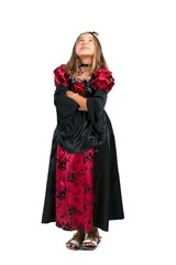 Fototapeta premium A full-length shot of a Blonde child dressed as a vampire for halloween holidays stand and looking up isolated on white