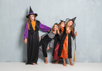 Group of friends with costumes of vampires and witches for halloween holidays making a joke