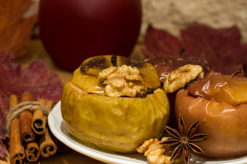 Baked apples with honey, cooked with red wine and brown sugar. Decorated with cnnamon, walnuts and anise stars. Close up.