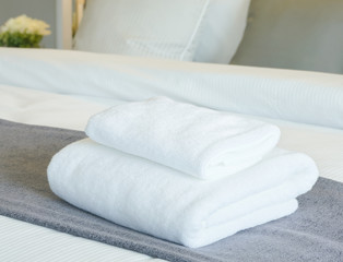 White towels on bed in modern bedroom interior