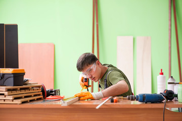 Young man carpenter working in workshop 