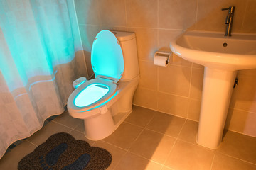 Toilet that Glows in a Standard Modern Bathroom.