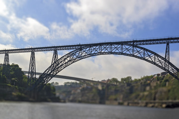 Tilt-shift effect photography. Maria Pia Bridge over the Douro river, Porto, Portugal. Panoramic view from the water. A great place for tourist trips.