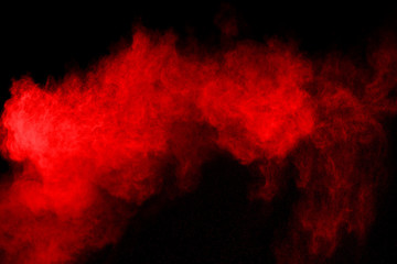 abstract red powder explosion on black background.abstract red powder splatted on black background. Freeze motion of red powder exploding.