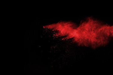 abstract red powder explosion on black background.abstract red powder splatted on black background....