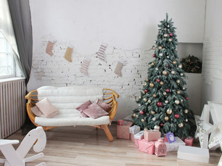 Christmas tree in a white room decorated with pink, gold and silver jewelry balls
