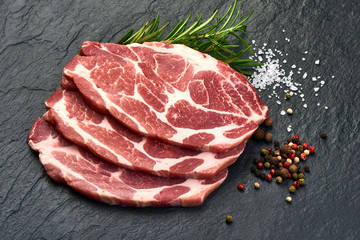 Meat, pork, slices pork loin with herbs on a slate shale plate.