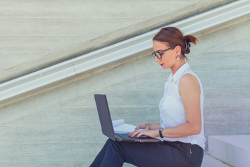 business woman working on laptop on stairs