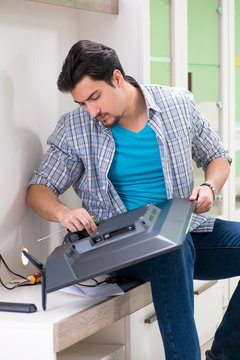 Young man husband repairing tv at home 