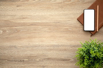 phone with isolated screen on wooden table with a notebook