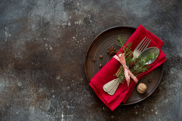 Chrismas table place setting. Tableware with evergreen twigs, cone and spice