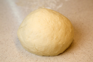 Close-up view of the homemade raw dough ball lying on the modern cooking surface