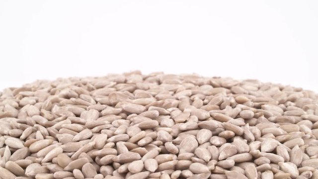 Pile of sunflower seed kernel rotating on the turntable, isolated on the white background. Close-up. Macro.