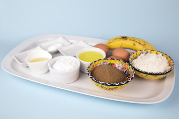 Basic ingredients (flour, egg, milk, olive oil, sugar, banana, salt) for a delicious homemade banana cake