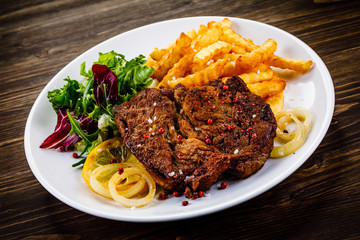 Grilled beefsteak with french fries and vegetable salad