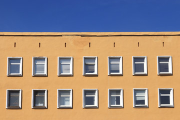 Windows house with blue sky. Building facade with many windows.