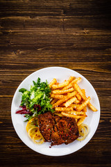 Grilled beefsteak with french fries and vegetable salad
