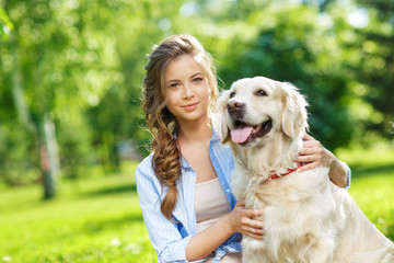Young woman with golden retriever dog in the summer park