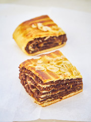 A portion of Kokosh, chocolate roll pastry, from traditional Jewish pastry, over a white paper.
