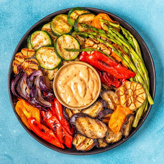 Grilled vegetables on a plate with sauce.