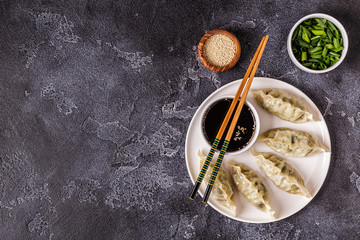 Asian dumplings, soy sauce, chopsticks, top view