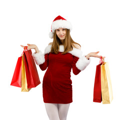 Beautiful woman in Santa Claus clothes holding shopping bags on white background