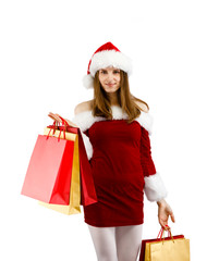 Beautiful woman in Santa Claus clothes holding shopping bags on white background