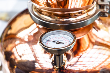 The thermometer on a copper pot for distillation of alcohol - obrazy, fototapety, plakaty