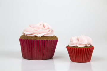 Colorful cupcakes, red and pink, with buttercream and heart figure candy.