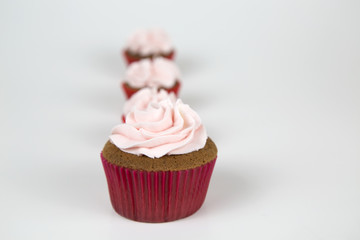 Colorful cupcakes, red and pink, with buttercream and heart figure candy.
