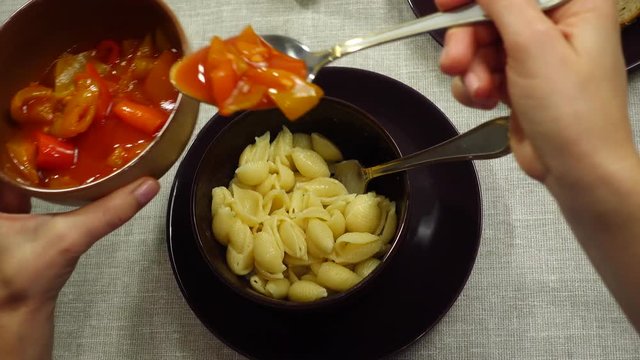 The process of eating pasta with lecho sauce.